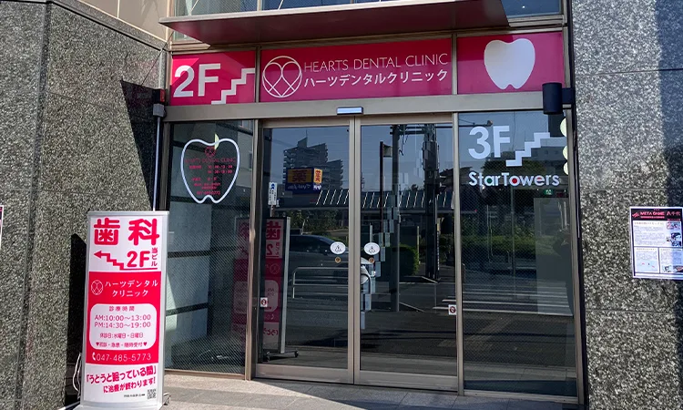 駅をでると目の前に見える赤い看板のあるビルにハーツデンタルクリニックがあります。